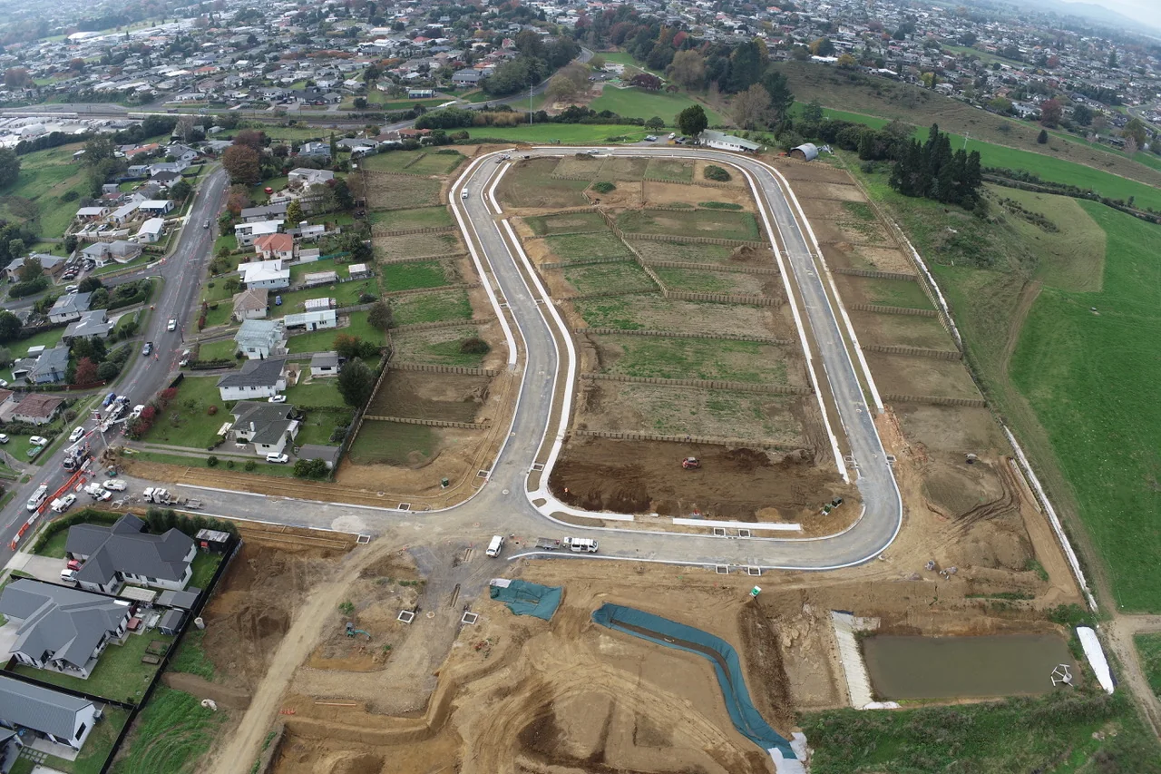 Aerial view of an R2 Developments subdivision showing stormwater pond and surrounding rural Waikato landscape
