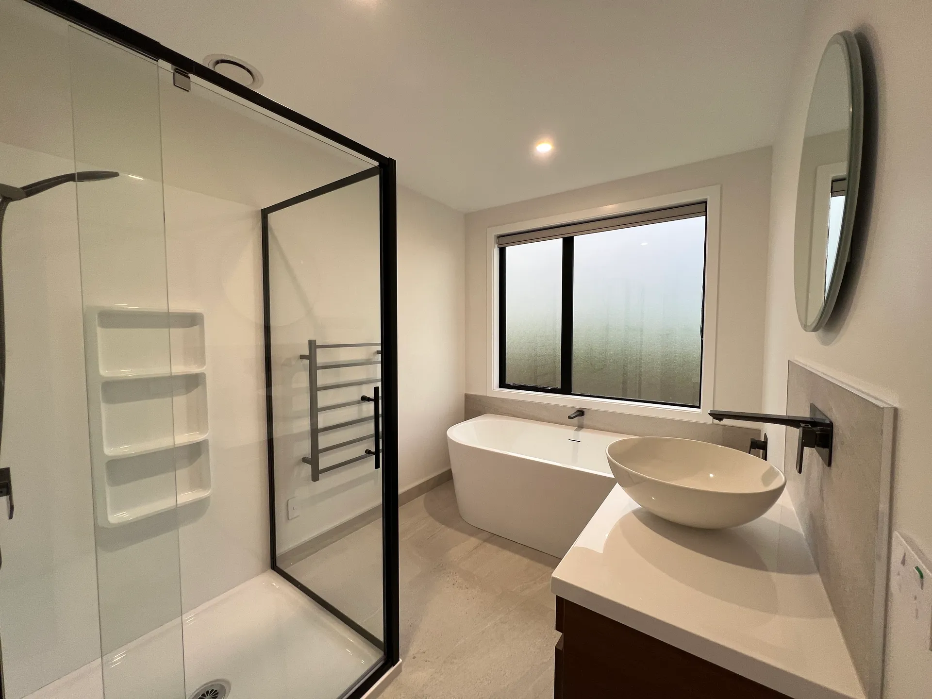 Bathroom with freestanding bath and black-frame shower