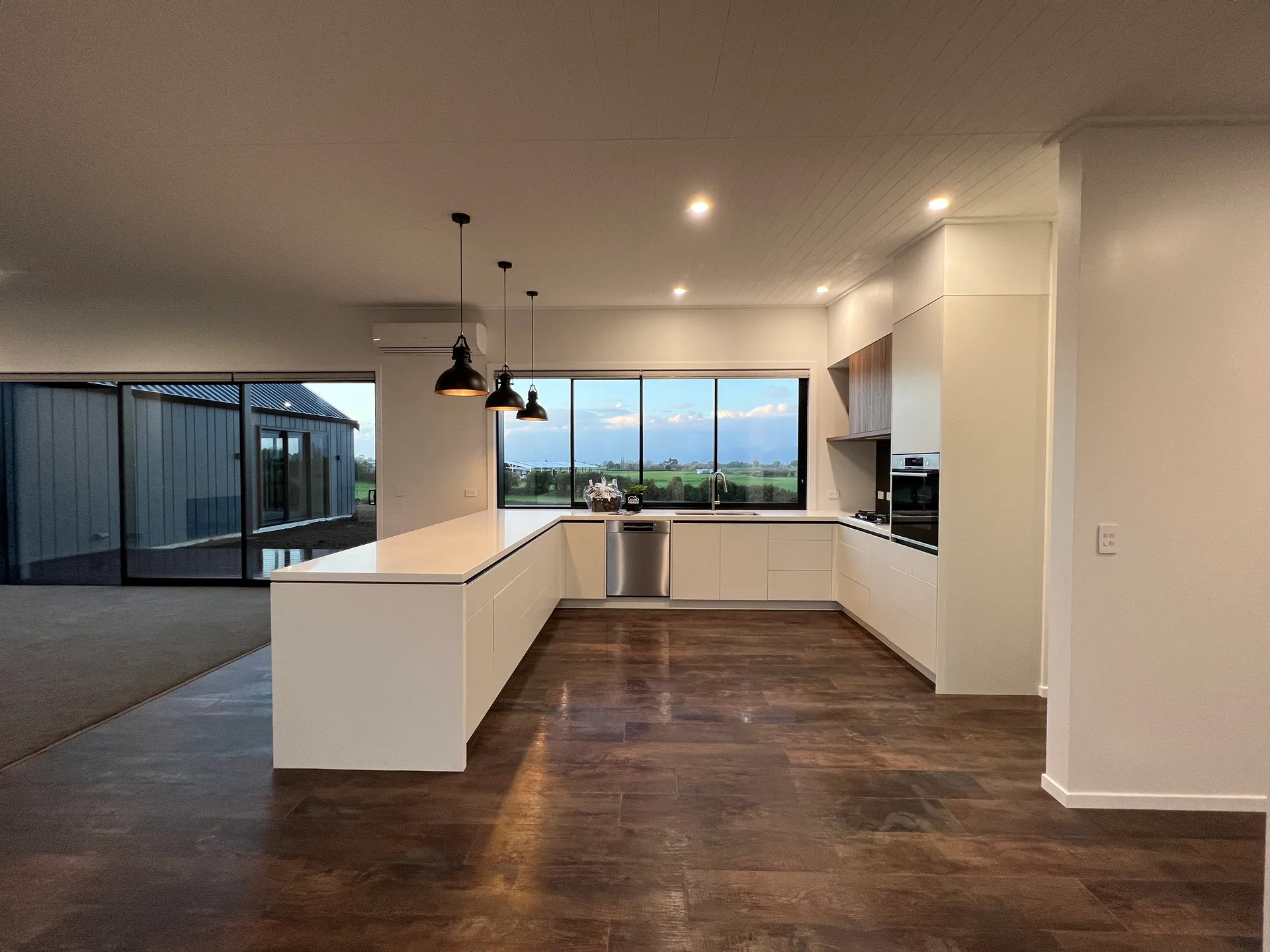 Kitchen with island bench and rural outlook