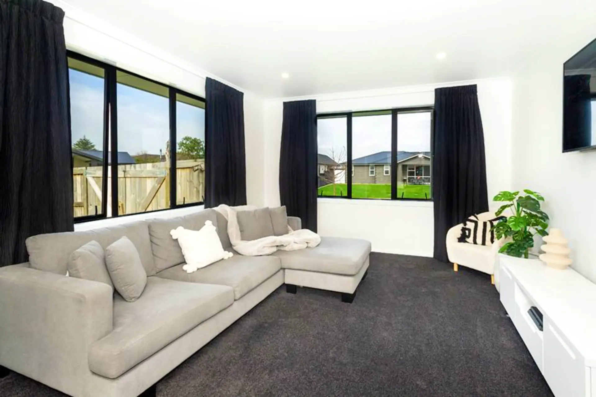 Living room with dark carpet and large windows