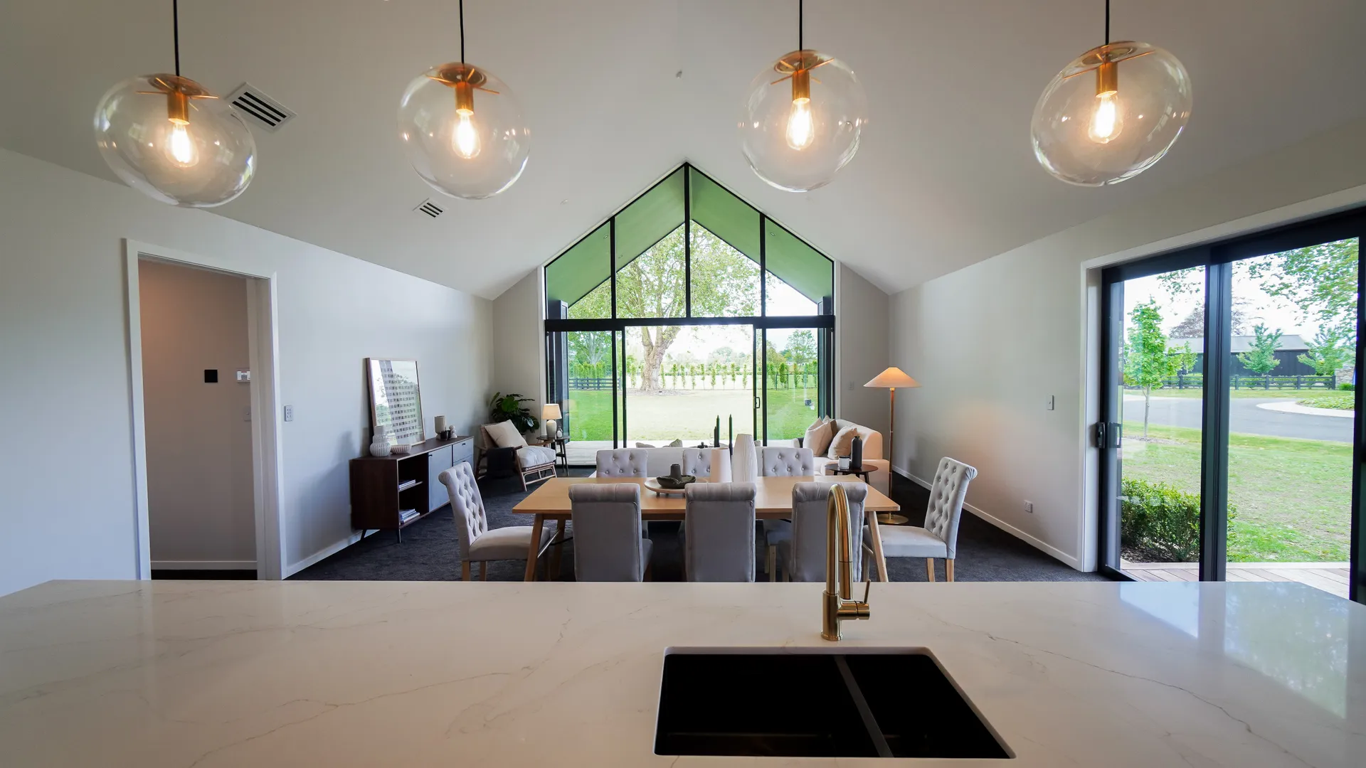 Vaulted-ceiling kitchen and dining of a Highgrove new build, looking out to rural grounds