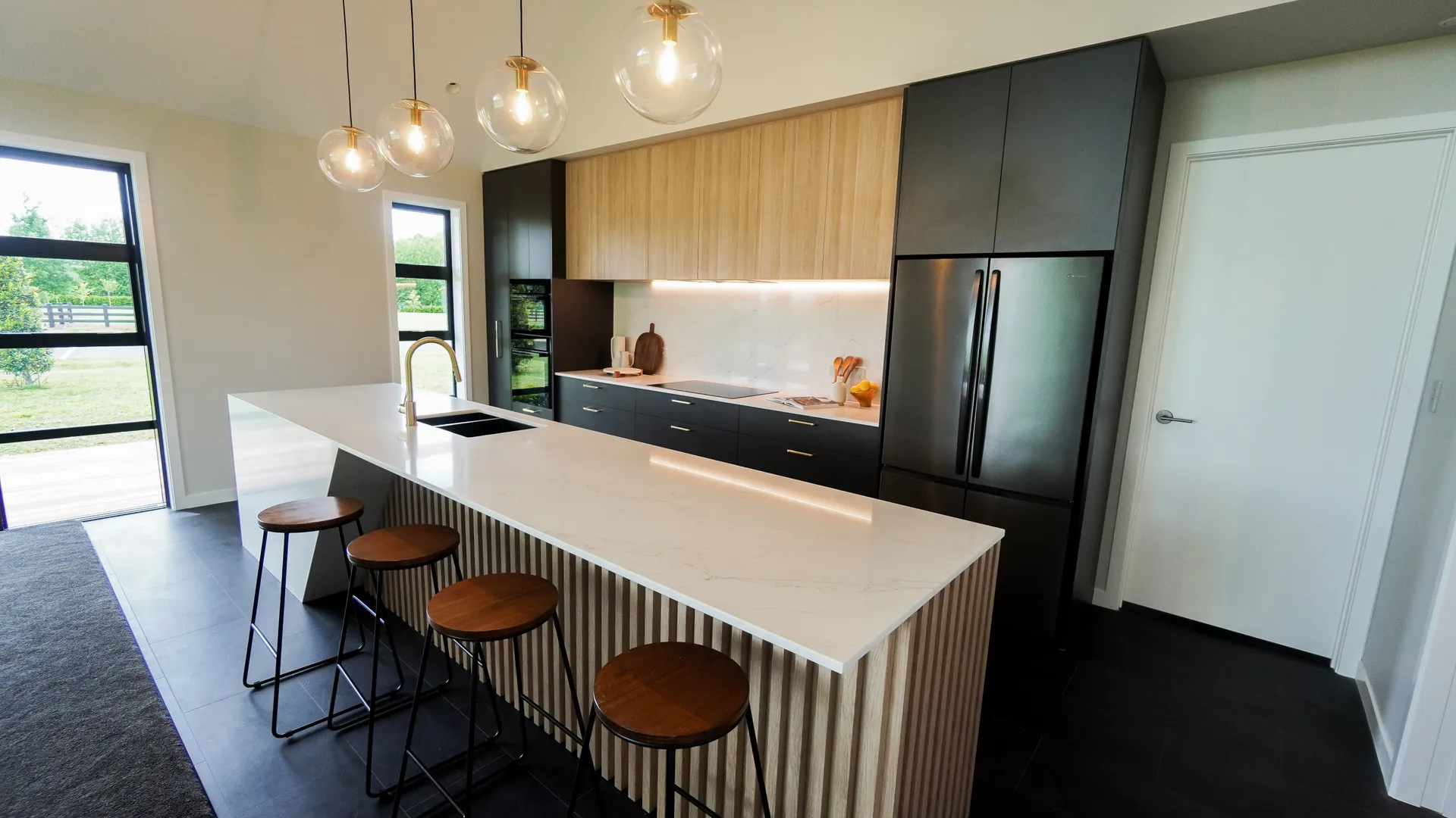 Designer kitchen with fluted island panel and timber stools
