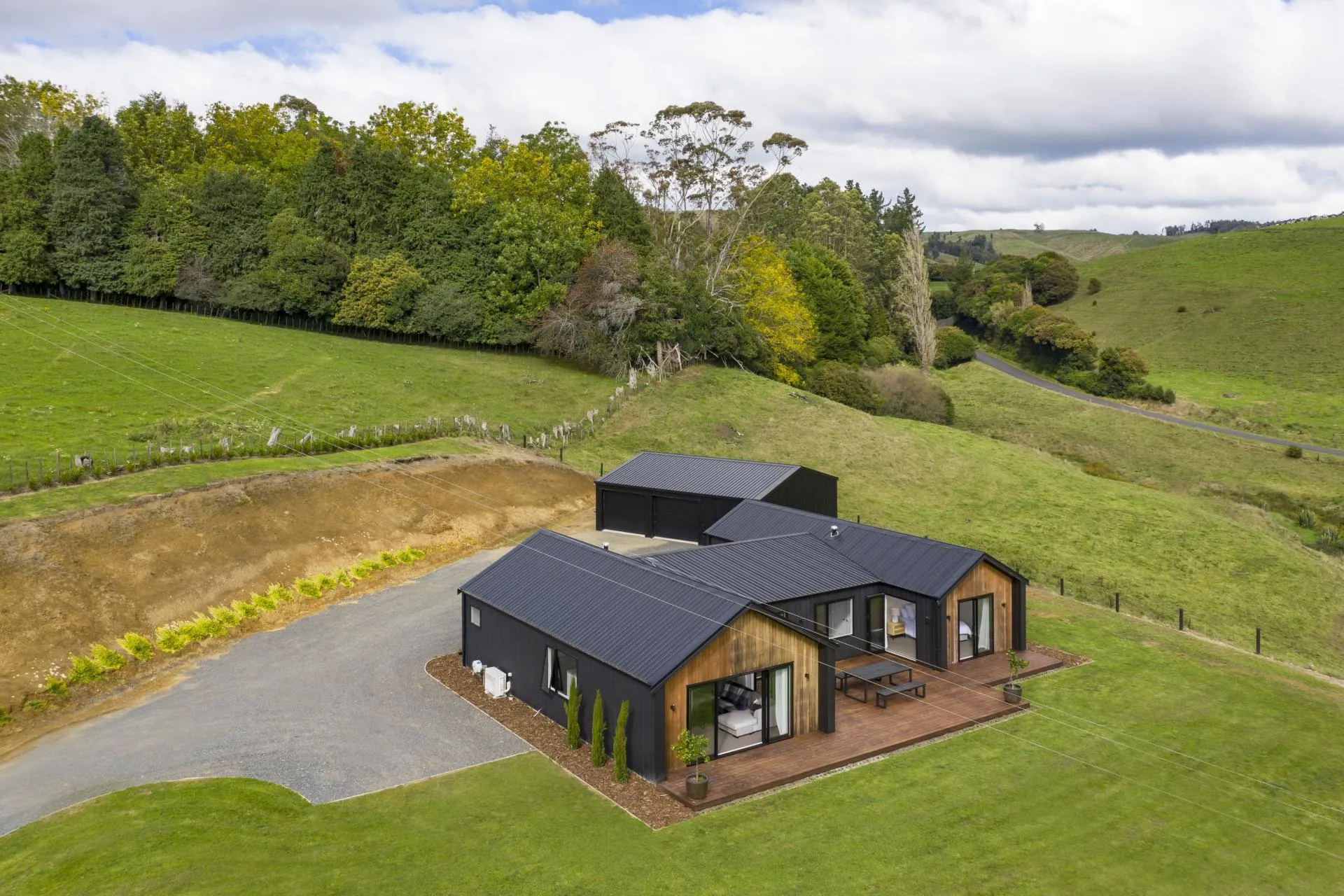 Aerial view of dark-clad rural home with cedar accents