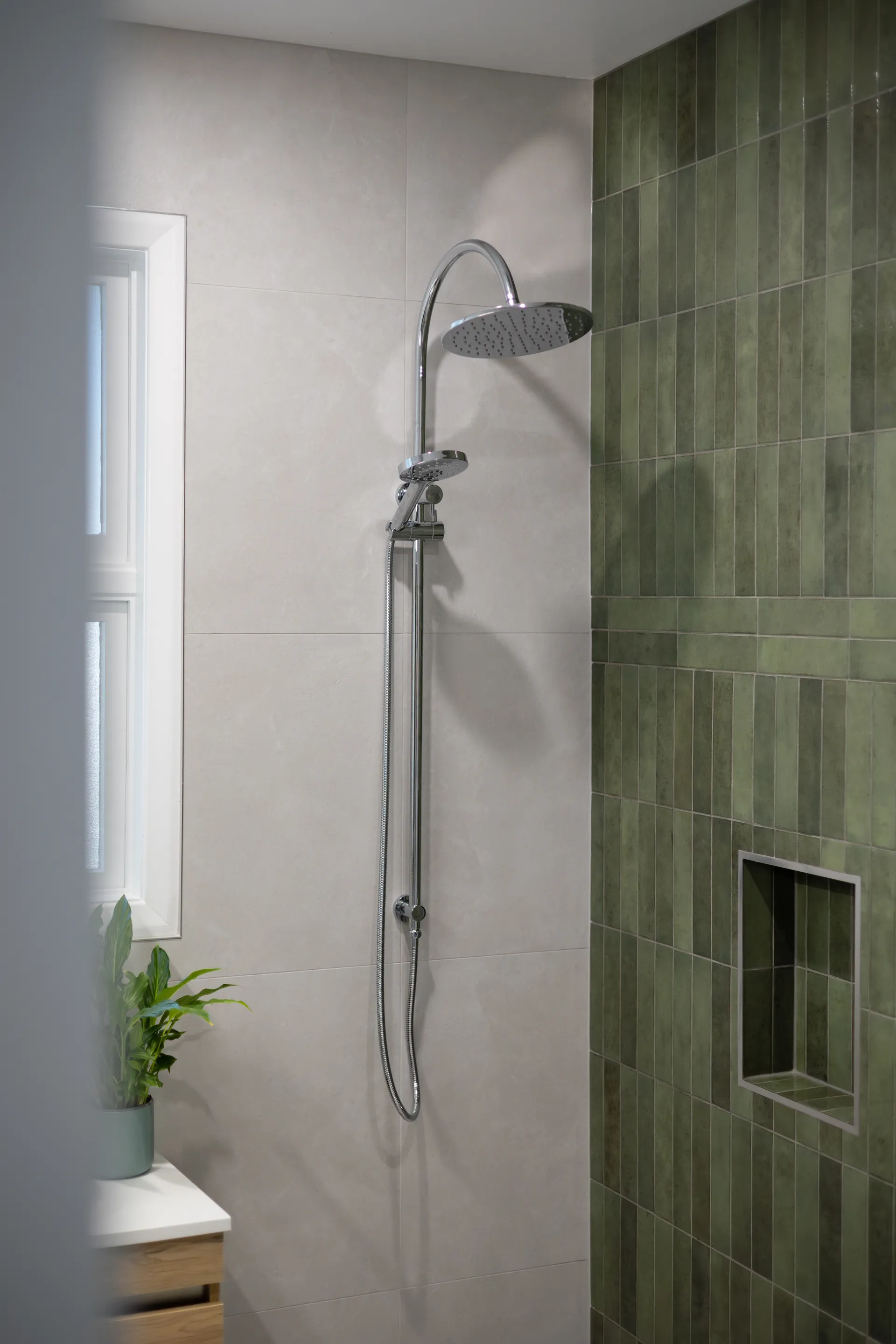 Chrome shower on green tile feature wall